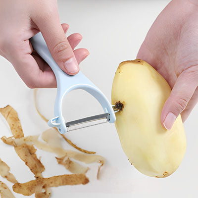 une madame qui nettoie les taches dans la pomme de terre grace a un eplucheur