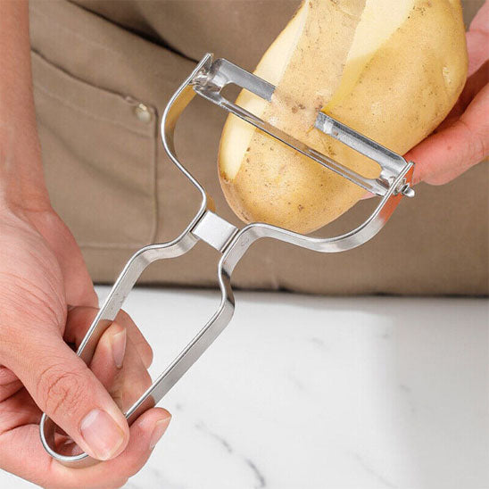 econome avec une lame pivotante pour eplucher un grande pomme de terre