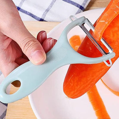 une madame qui epluche une carotte avec un eplucheur a lame pivotante