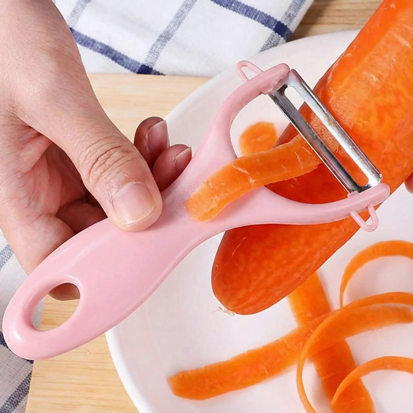 une madame qui epluche une carotte avec un eplucheur a lame pivotante