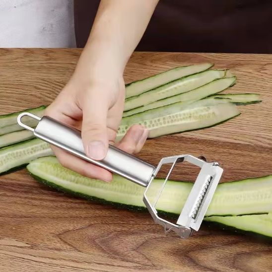 une personne qui epluche des tranches fins avec la rape a legumes manuelle