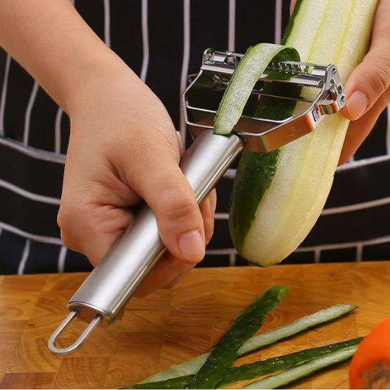 une personne qui epluche un concombre avec une rape a legumes manuelle