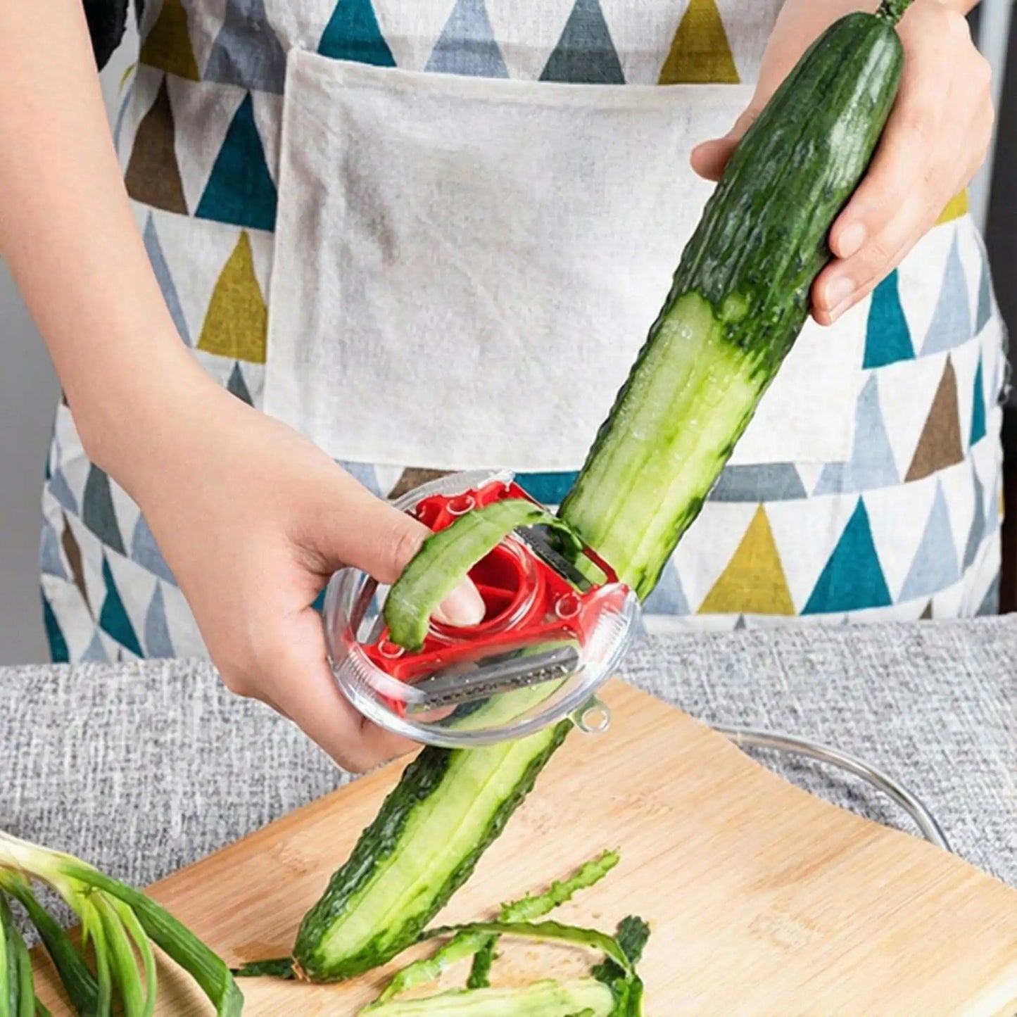 une personne qui utilise un eplucheur rouge pour eplucher un concombre
