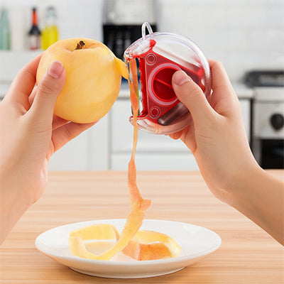une personne utilise un eplucheur de couleur rouge pour eplucher une pomme
